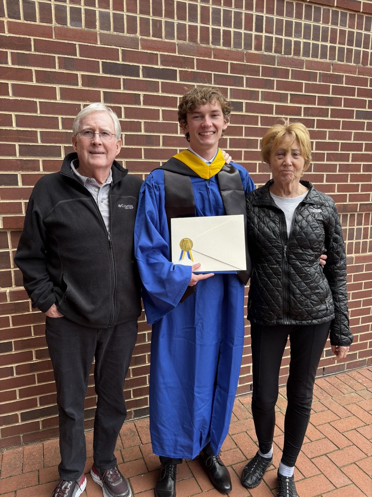 The founder of Sollund Health standing with his grandfather and grandmother at his graduation.